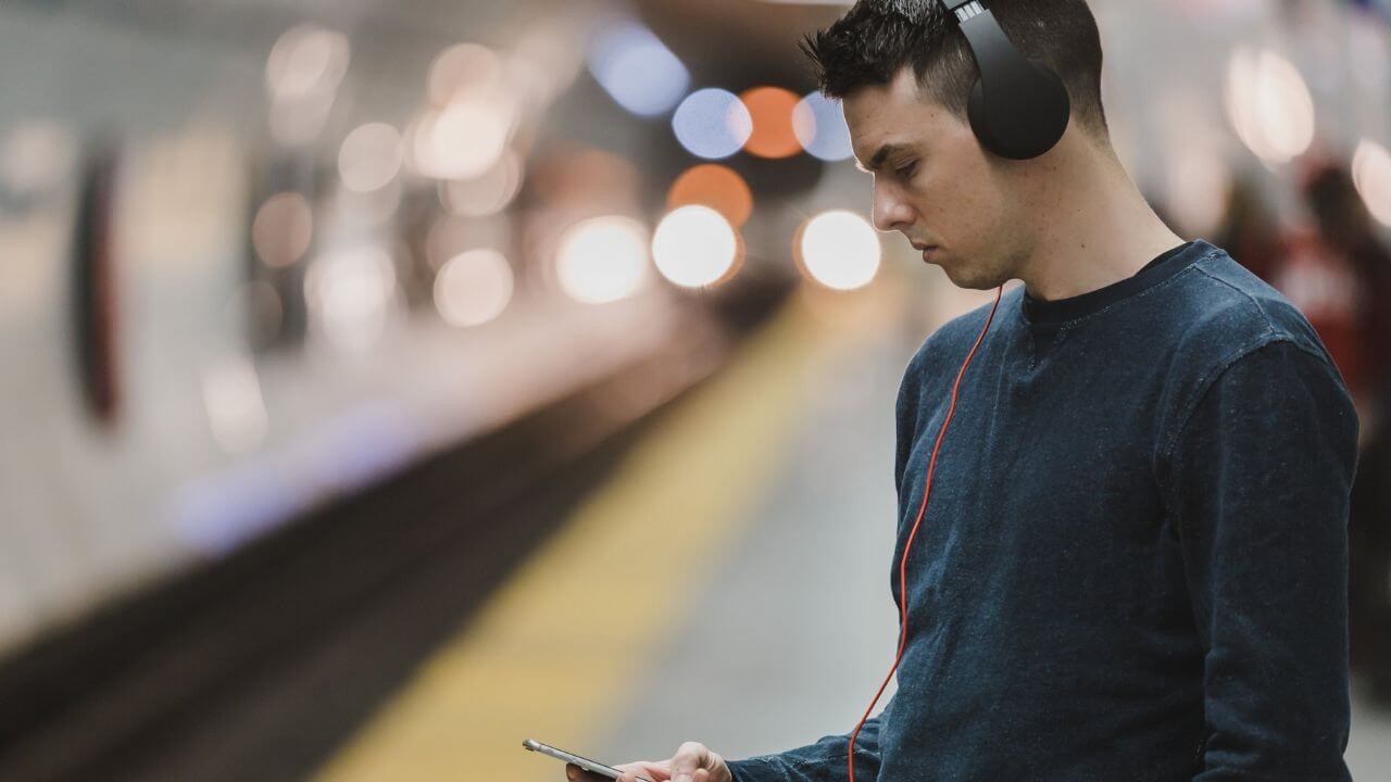 Young man listening to podcast on headphones
