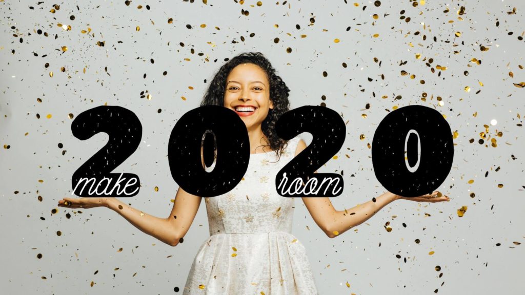 Woman holding up 2020 with gold glitter falling